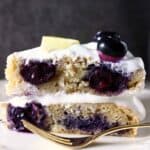 A slice of lemon blueberry layer cake against a grey background