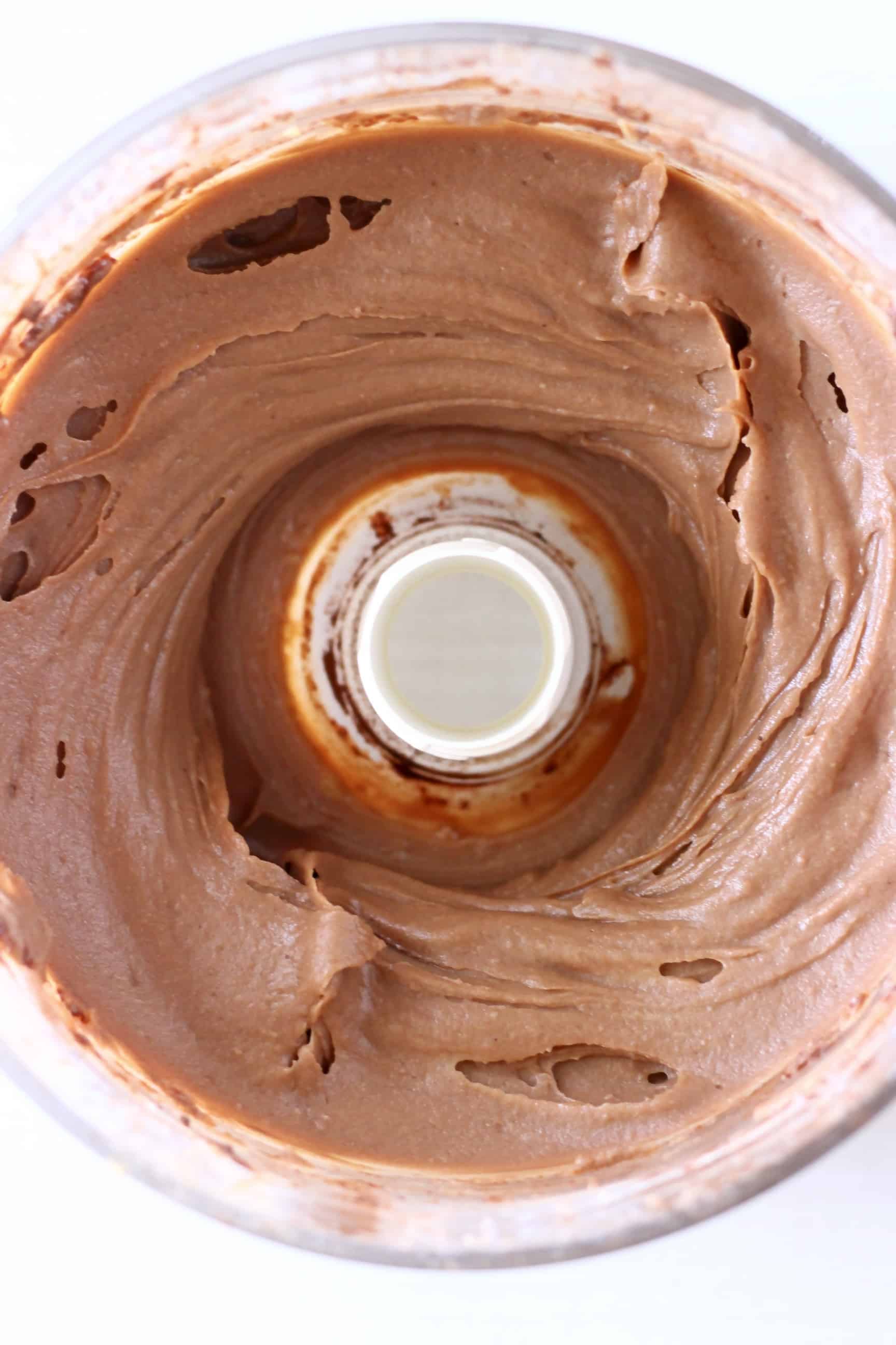 Chocolate pie filling in a food processor against a white background