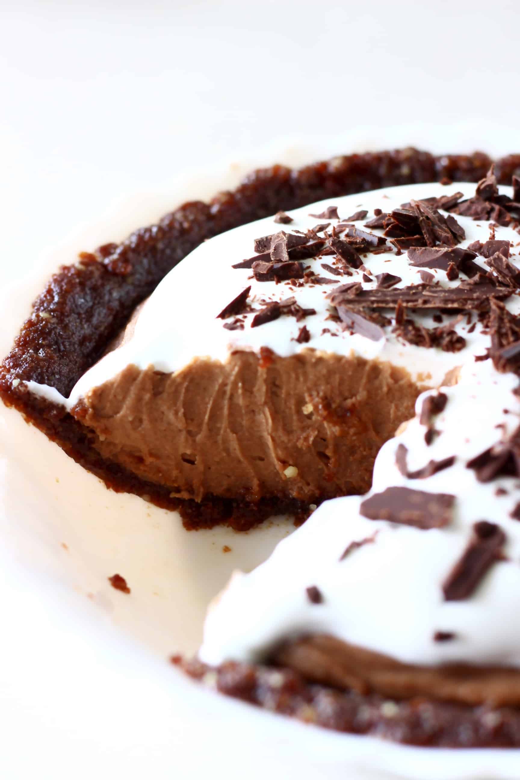 Chocolate pie in a pie dish with a slice cut out of it against a white background