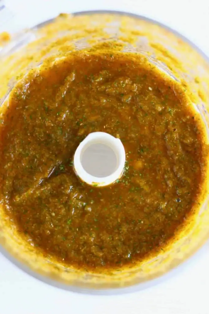 Photo of a brown carnitas sauce in a food processor taken from above