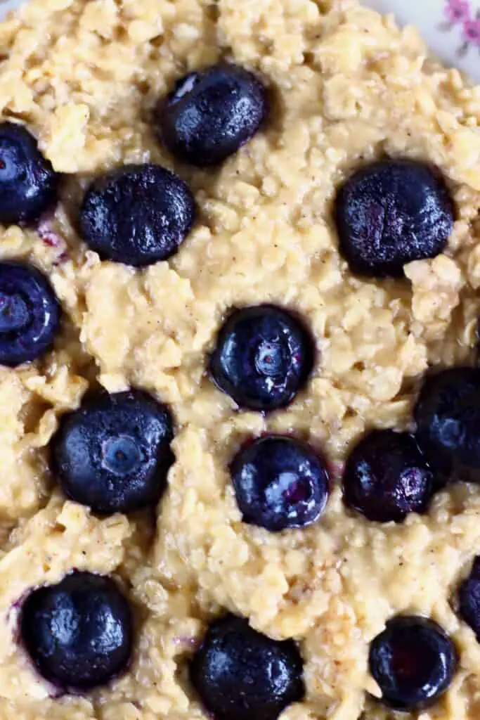 Oatmeal cookie dough dotted with fresh blueberries in a mixing bowl taken from above