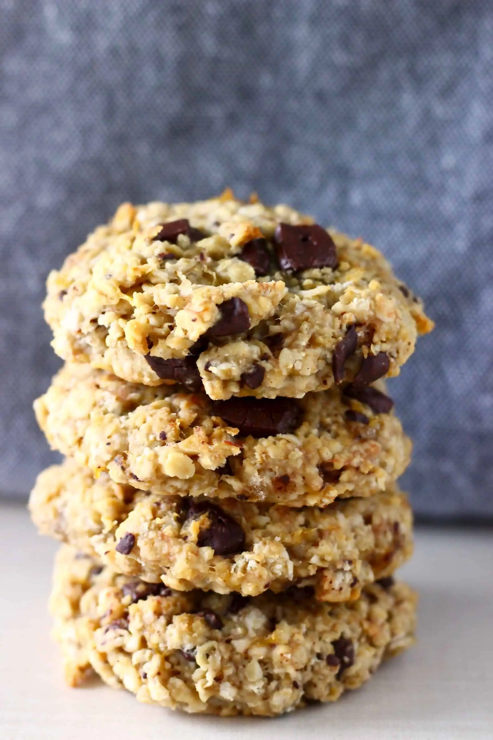 A stack of four gluten-free vegan banana oatmeal cookies with chocolate chips