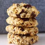 A stack of four gluten-free vegan banana oatmeal cookies with chocolate chips