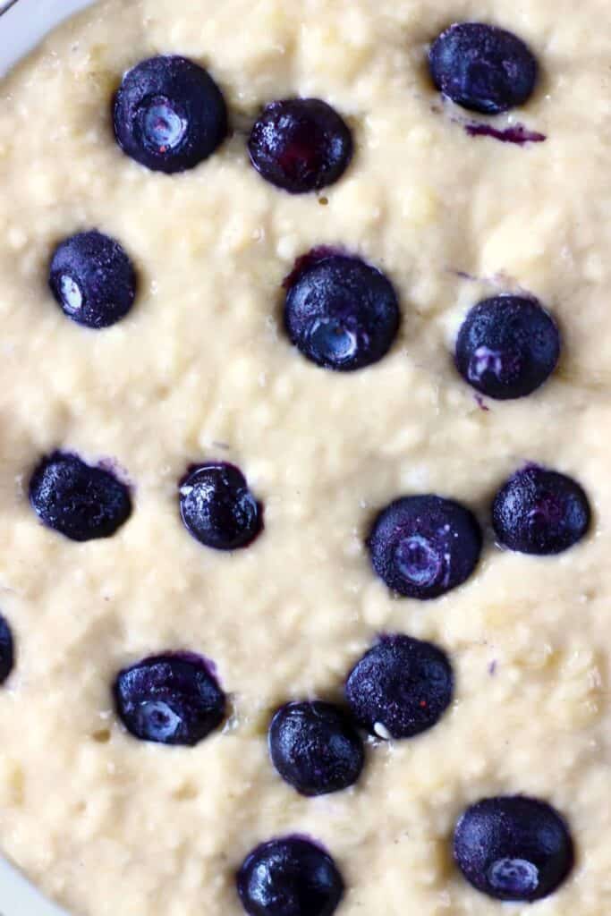 These Gluten-Free Vegan Blueberry Pancakes are super moist, fluffy, perfectly sweet and fruity. They're made in one bowl, and made using simple ingredients without egg replacements, flax eggs or aquafaba. They're egg-free, dairy-free and refined sugar free. They're great for breakfast, brunch, dessert or a snack. #vegan #dairyfree #glutenfree #blueberry #pancakes #veganpancakes #breakfast #brunch #dessert #refinedsugarfree Photo of yellow pancake batter with fresh blueberries in a mixing bowl taken from above