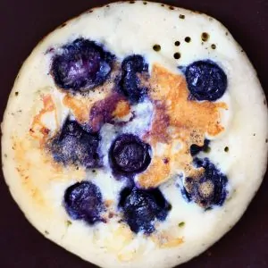 Photo of a blueberry pancake in a frying pan