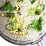 Photo of a saucepan with white stew with white beans, sweetcorn and green pepper