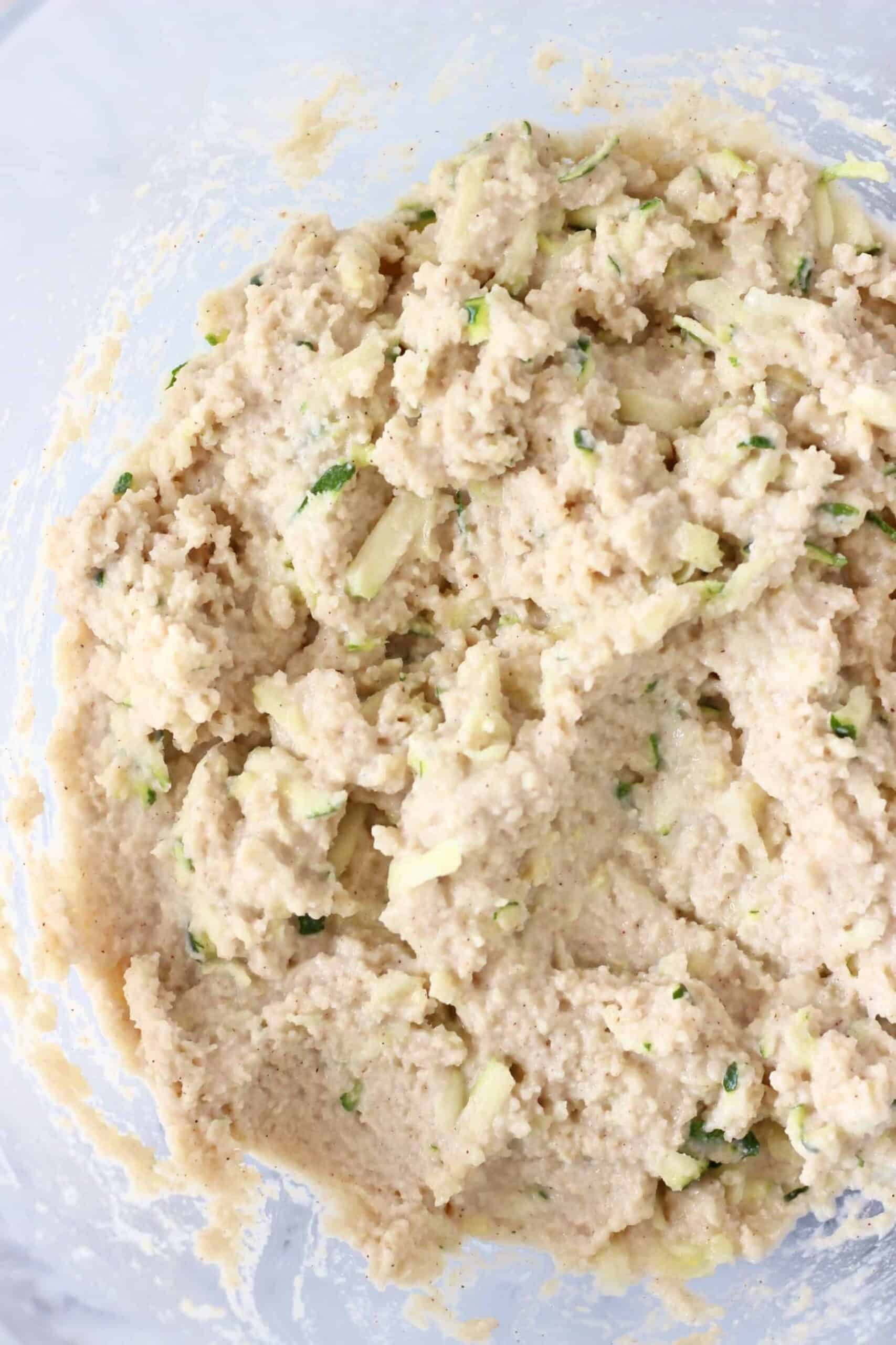 This Gluten-Free Vegan Zucchini Bread is seriously moist, perfectly dense and subtly fragrant. It's made with grated zucchini and subtly spiced with cinnamon for a warm, toasty flavour. It makes the perfect dessert, breakfast, brunch or snack, especially for autumn/fall. #vegan #dairyfree #rhiansrecipes #zucchinibread #glutenfree #baking A bowl of raw gluten-free vegan zucchini bread batter in a bowl