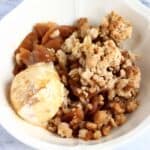 Gluten-free vegan apple crumble with a scoop of ice cream in a bowl