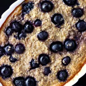 Vegan blueberry banana baked oatmeal in a white oval dish