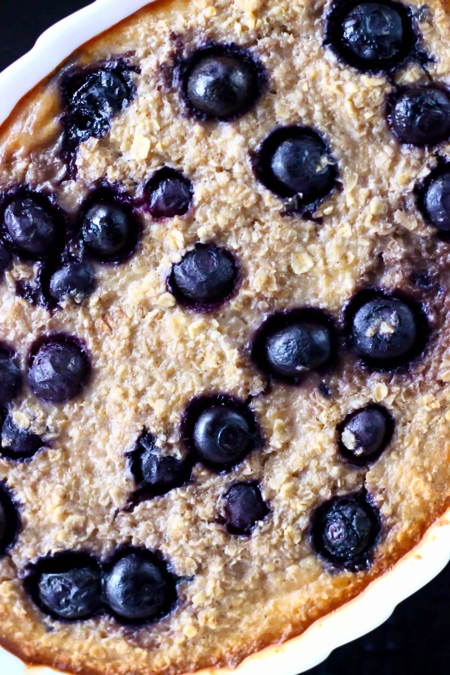 Vegan blueberry banana baked oatmeal in a white oval dish