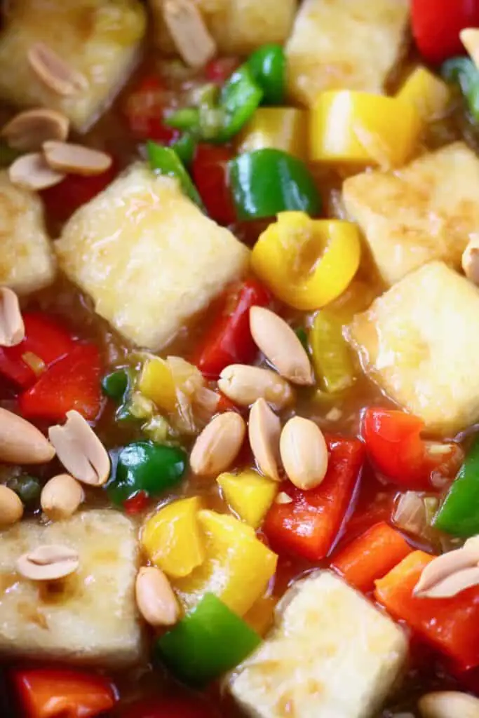 Photo of tofu cubes, peppers and peanuts in a frying pan