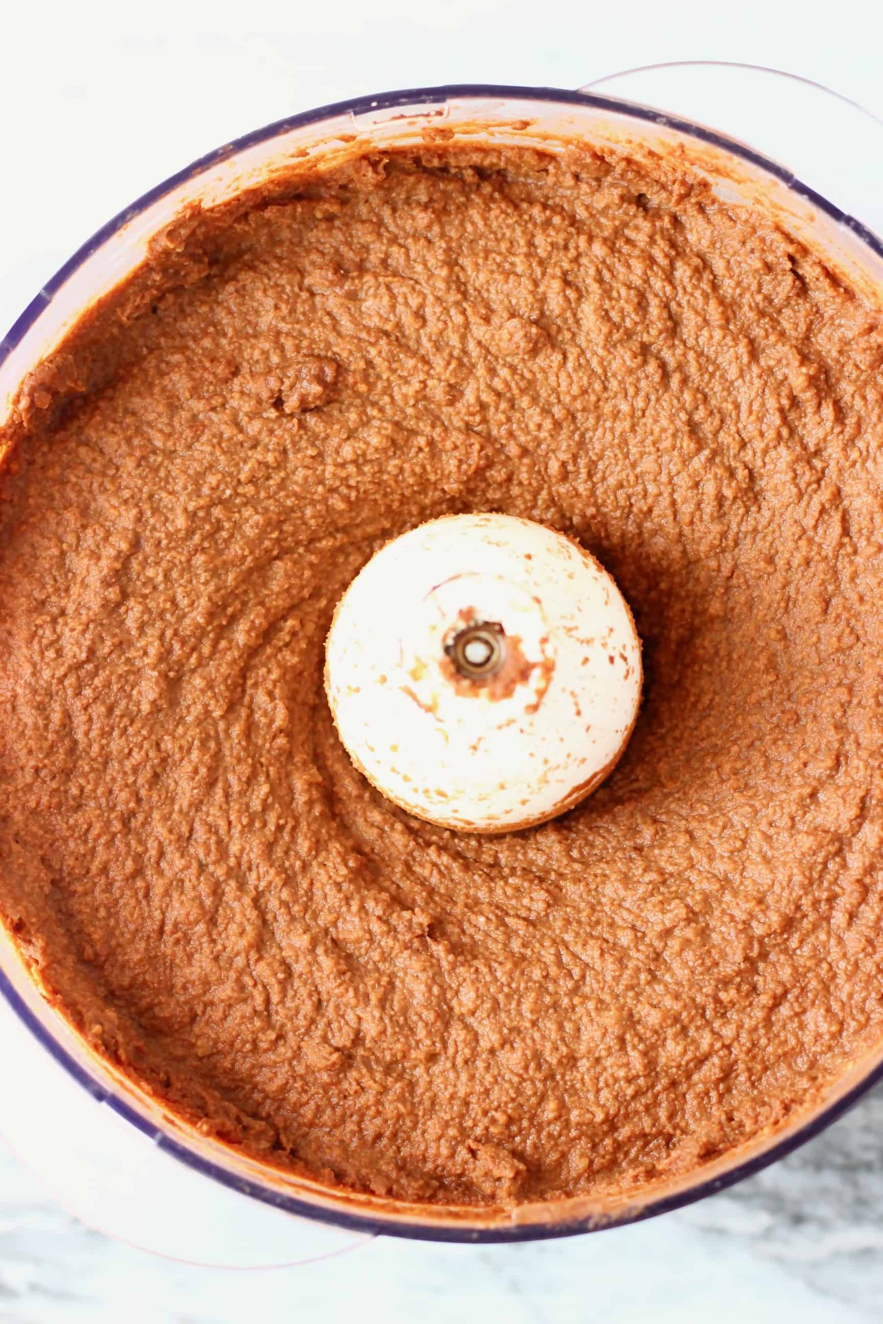 These Sweet Potato Brownies are seriously fudgy, rich and indulgent. They're made in just one bowl (food processor) and are vegan, dairy-free, egg-free, gluten-free, grain-free, refined sugar free, date-sweetened and oil-free. The best healthy dessert! #rhiansrecipes #vegan #brownies #sweetpotato #dessert #gluten-free #dairyfree #grainfree #oilfree Raw sweet potato brownie batter in a food processor