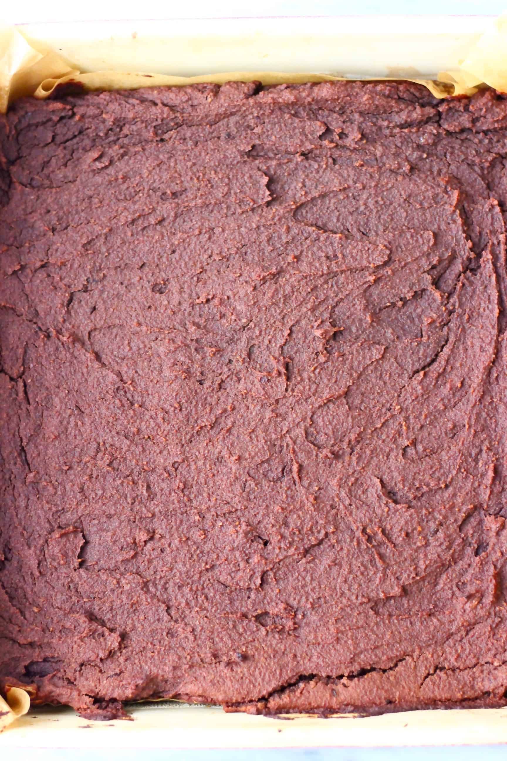 These Sweet Potato Brownies are seriously fudgy, rich and indulgent. They're made in just one bowl (food processor) and are vegan, dairy-free, egg-free, gluten-free, grain-free, refined sugar free, date-sweetened and oil-free. The best healthy dessert! #rhiansrecipes #vegan #brownies #sweetpotato #dessert #gluten-free #dairyfree #grainfree #oilfree Baked sweet potato brownies in a square baking tin lined with baking paper