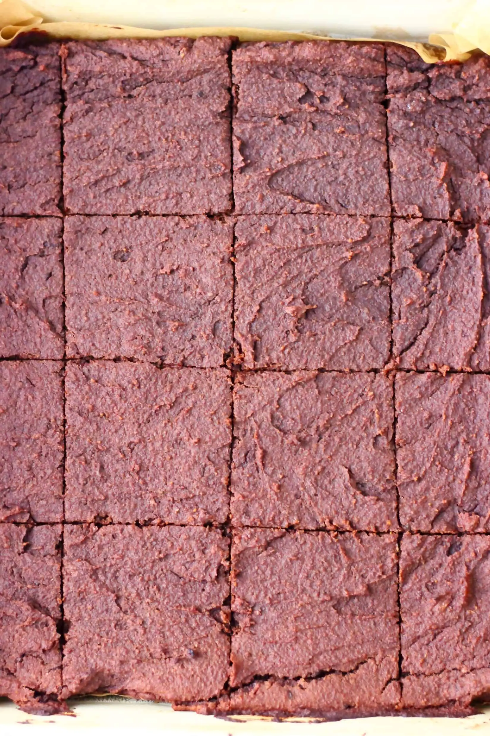 Baked sweet potato brownies cut into squares in a square baking tin lined with baking paper
