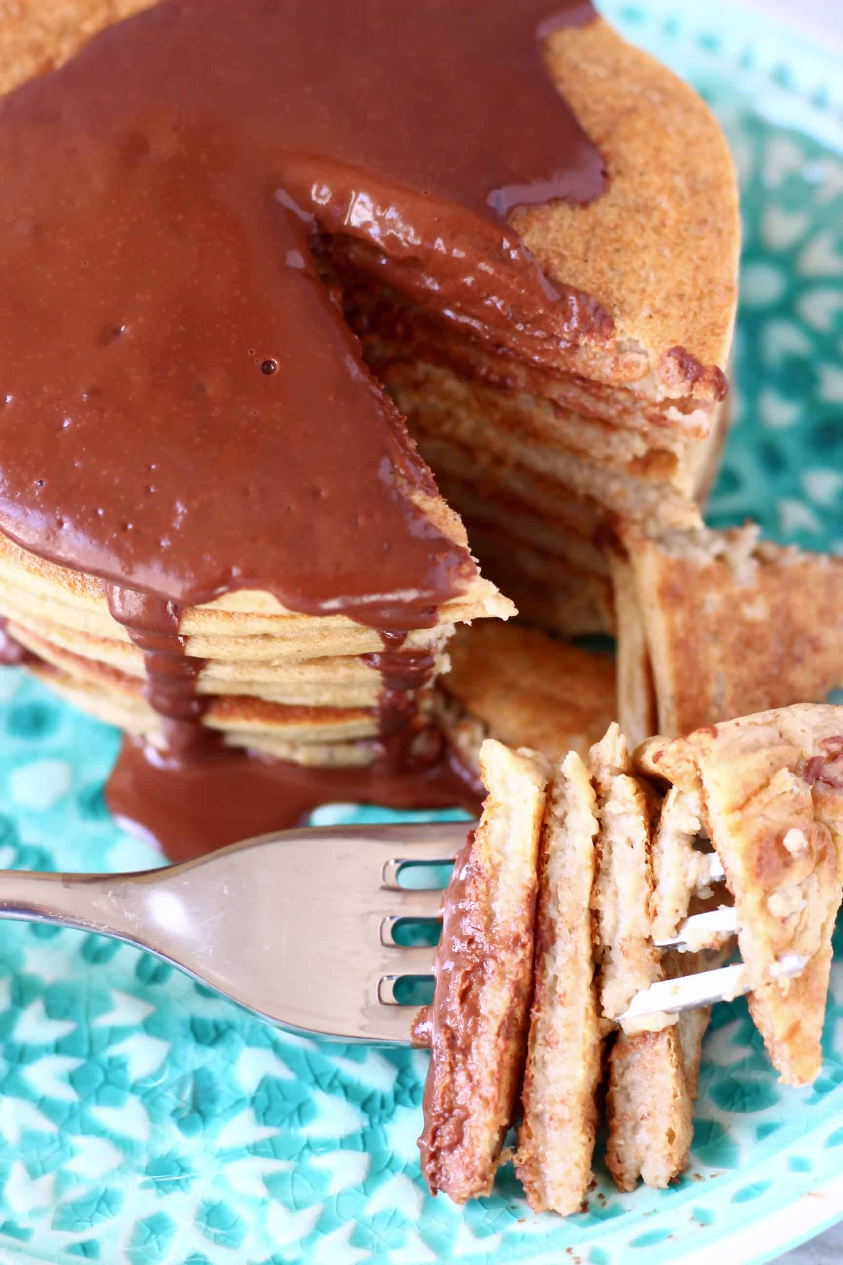 A stack of gluten-free vegan protein pancakes with a fork sticking through a mouthful