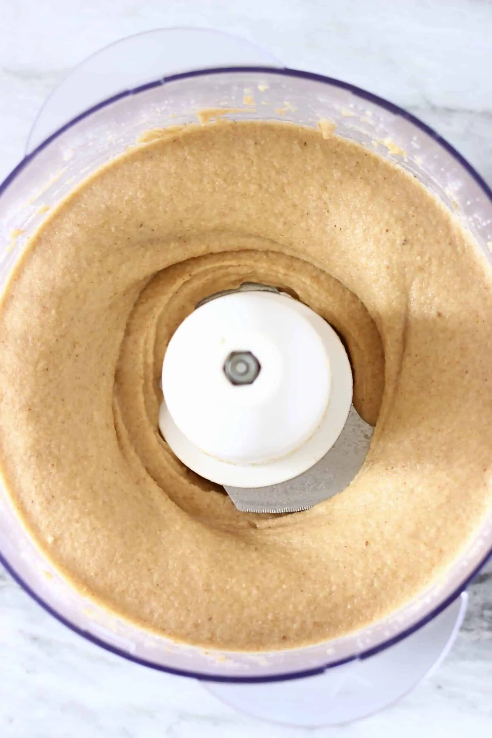 Caramel-coloured vegan fudge mixture in a food processor