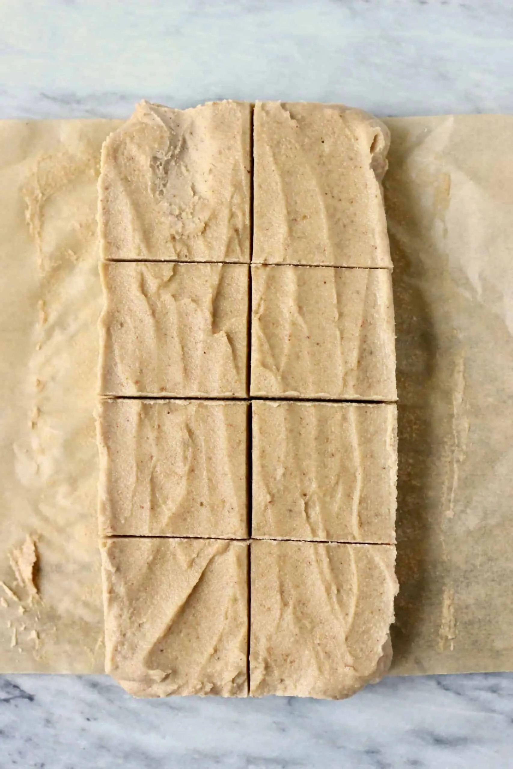 Eight squares of vegan fudge on a sheet of baking paper
