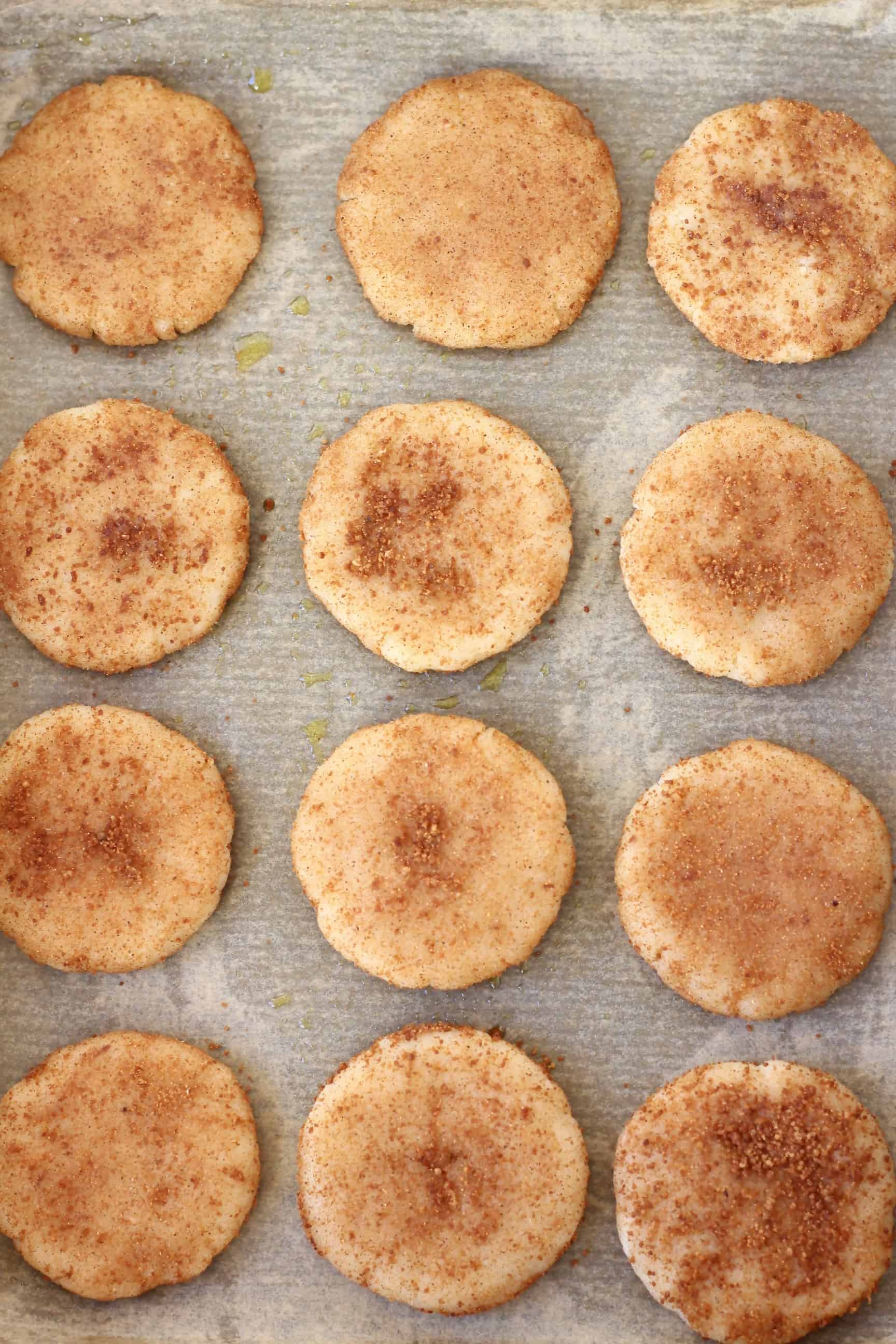 Twelve raw gluten-free vegan snickerdoodles on a baking tray lined with baking paper