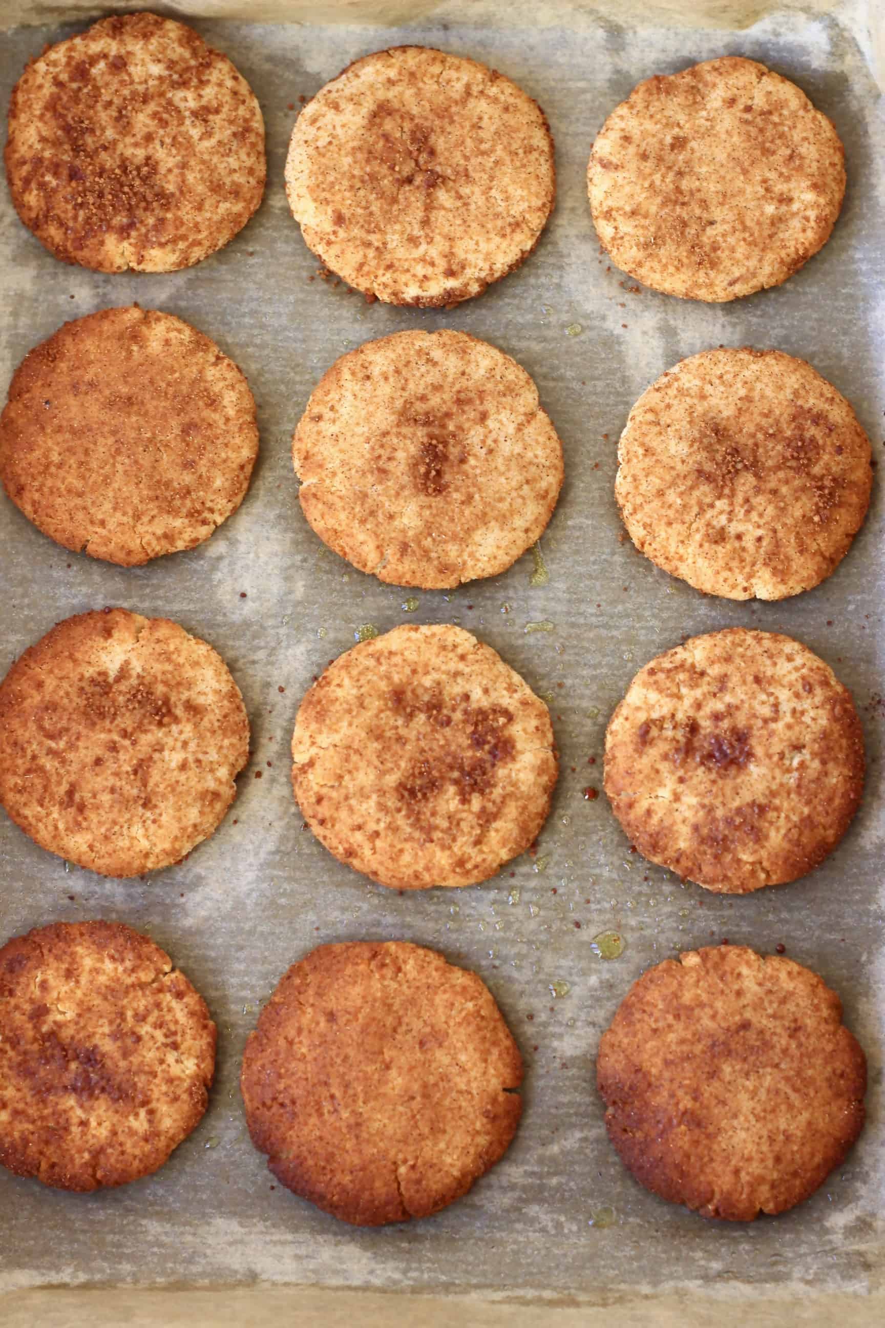 Twelve gluten-free vegan snickerdoodles on a baking tray lined with baking paper