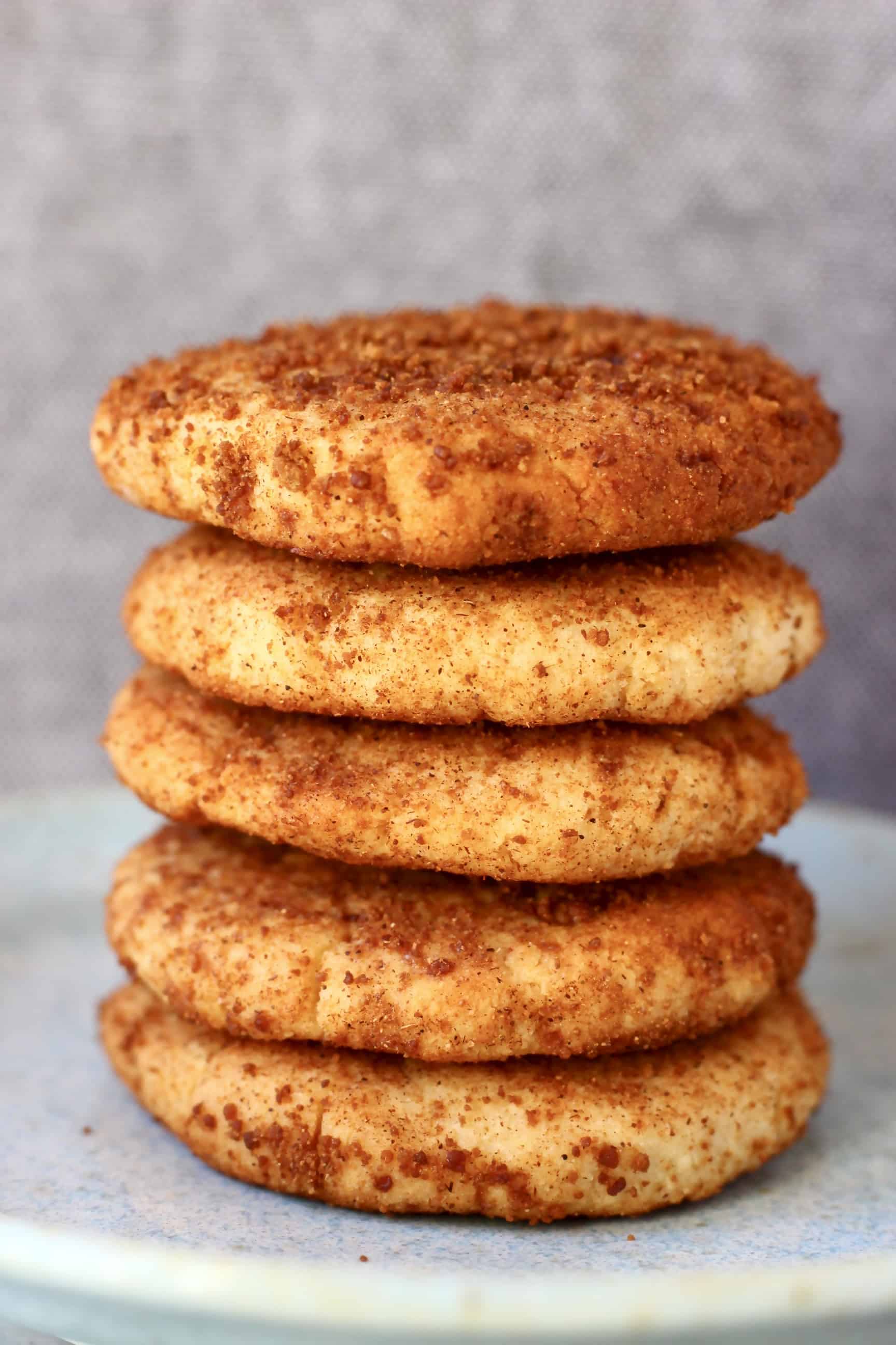 Five gluten-free vegan snickerdoodles stacked on top of each other on a plate