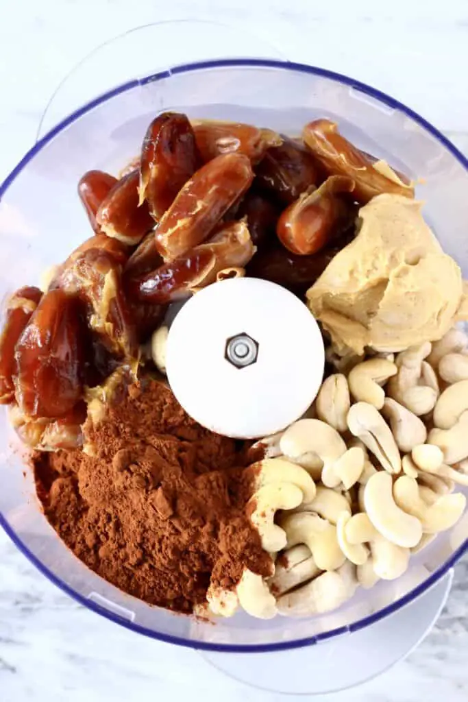 Photo of cocoa powder, cashew nuts, dates and almond butter in a food processor