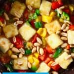 Photo of tofu cubes, peppers and peanuts in a frying pan