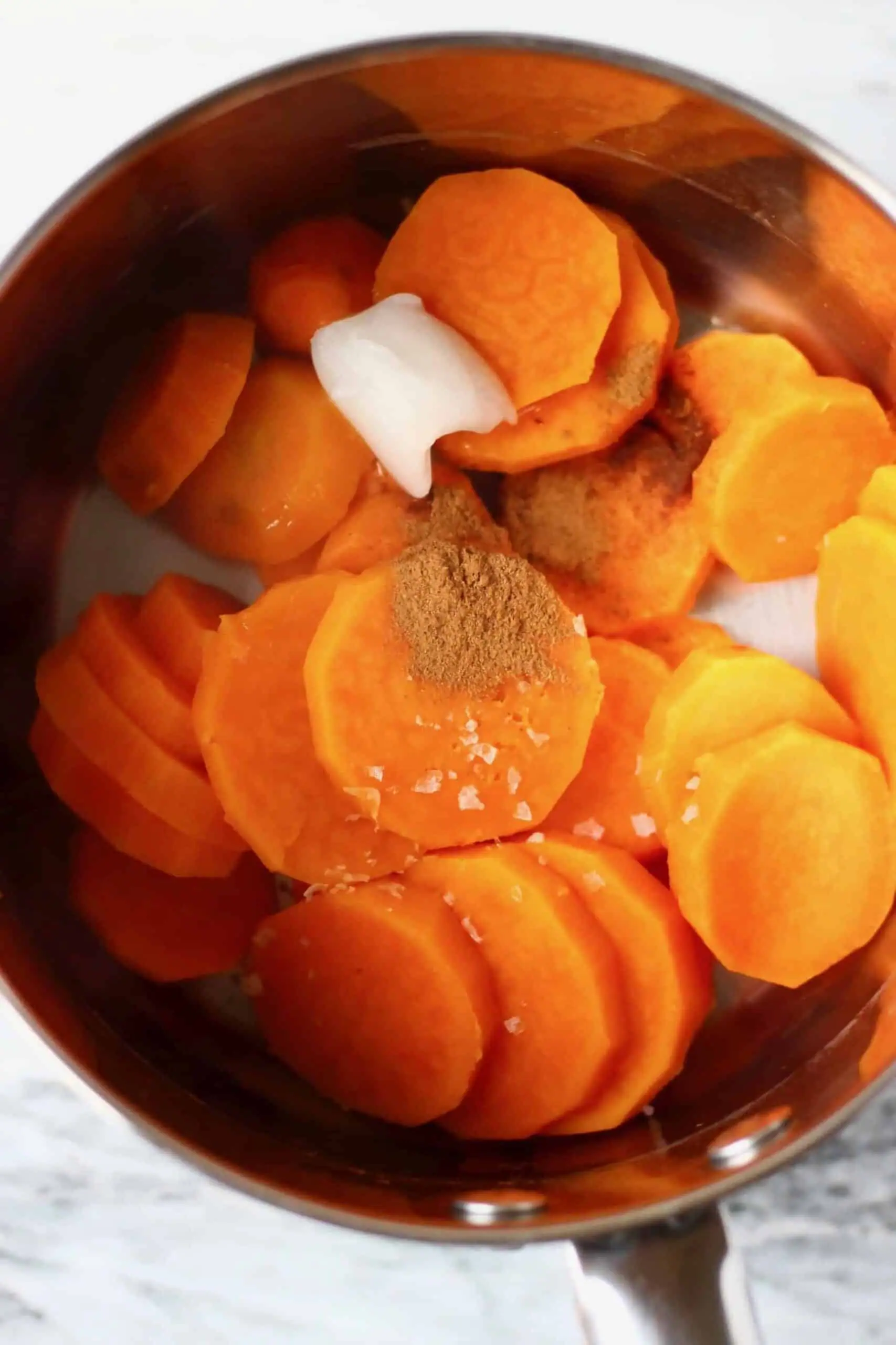 Cooked sweet potatoes, coconut oil and spices in a pan