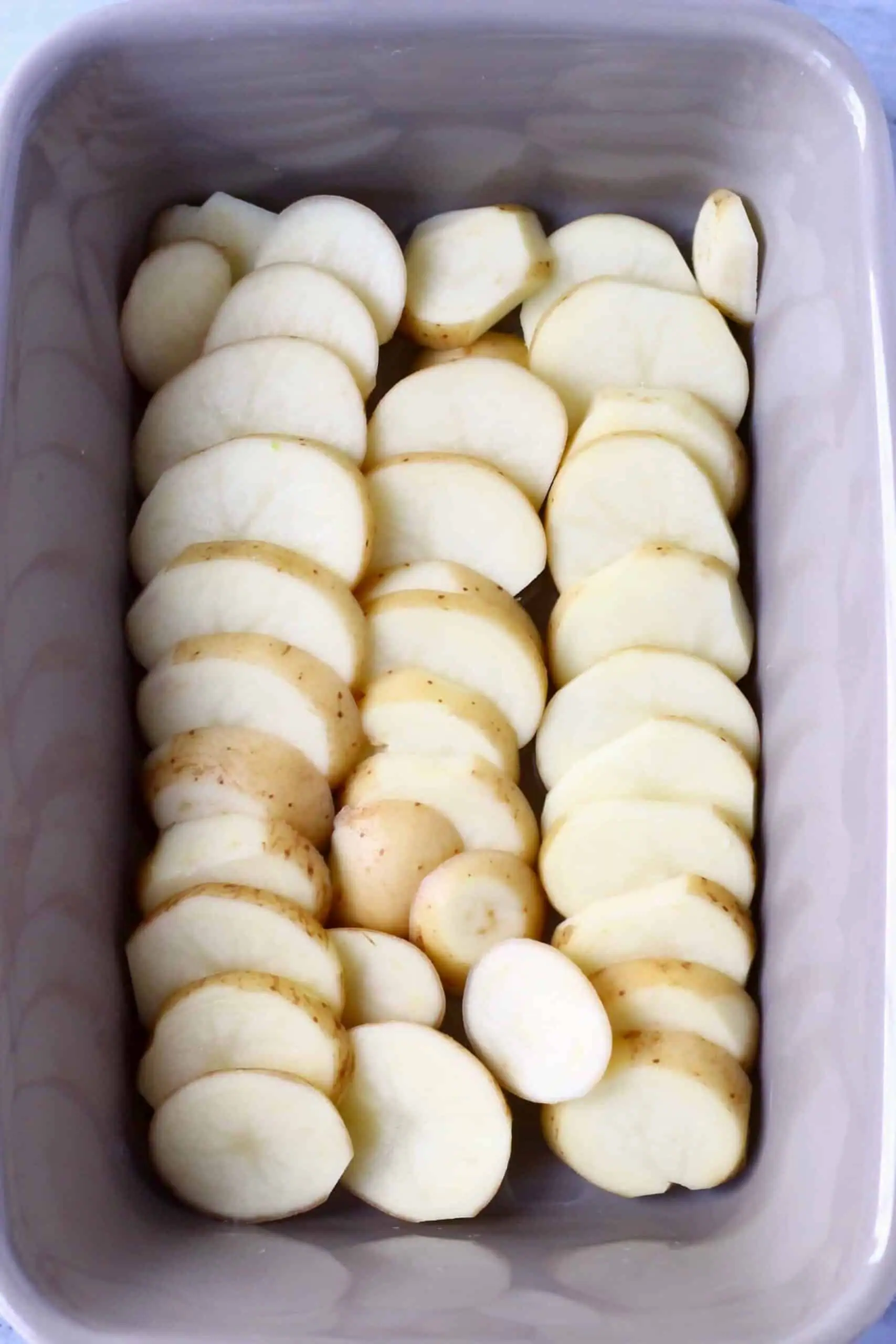 Sliced potatoes in a rectangular baking dish