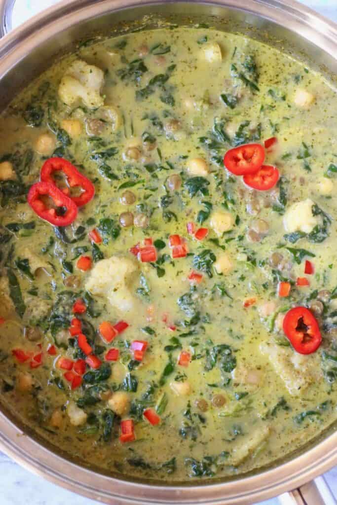 Photo of green curry with spinach, lentils, chickpeas and cauliflower in a silver saucepan