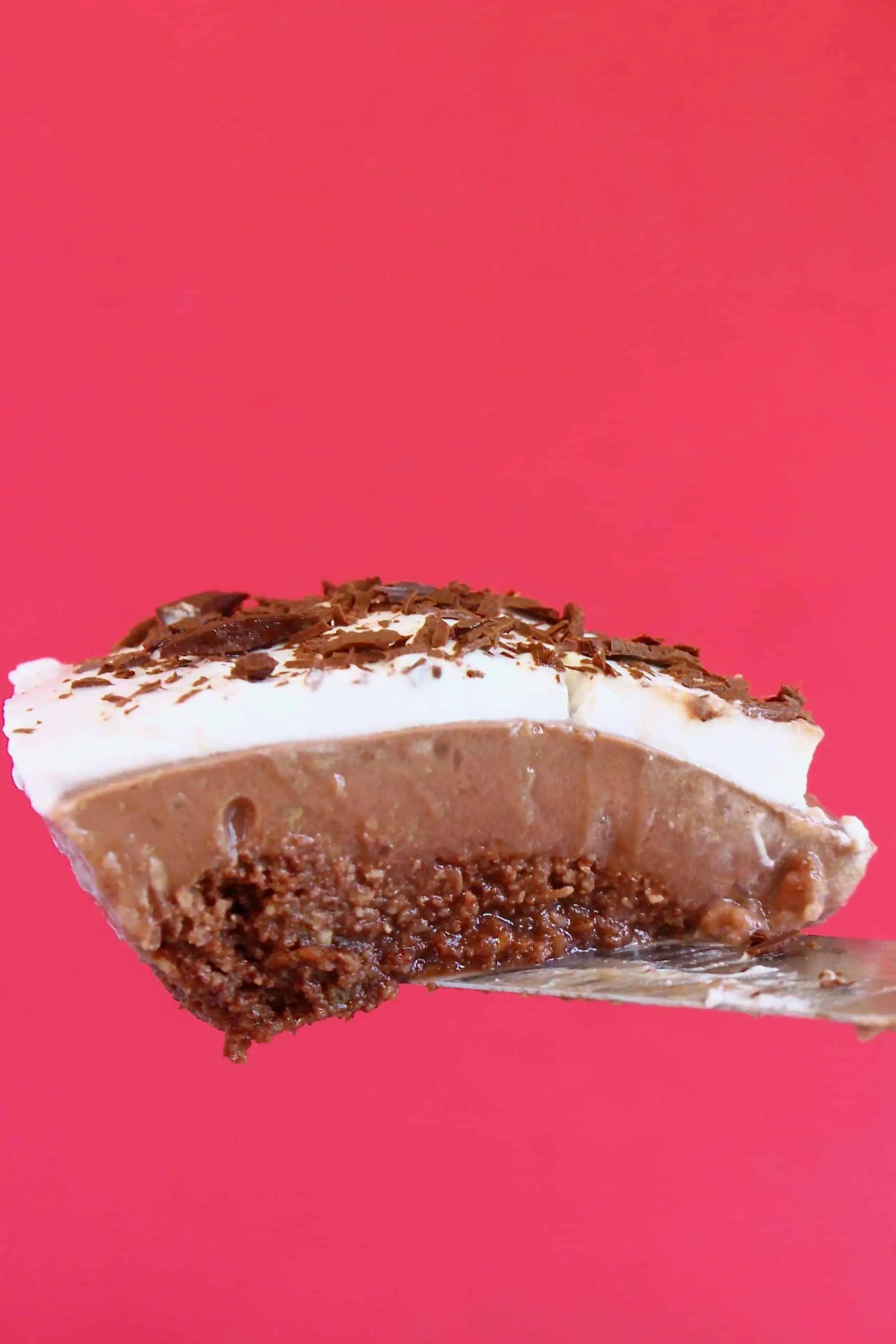A slice of chocolate pie topped with whipped cream and chocolate shavings 
