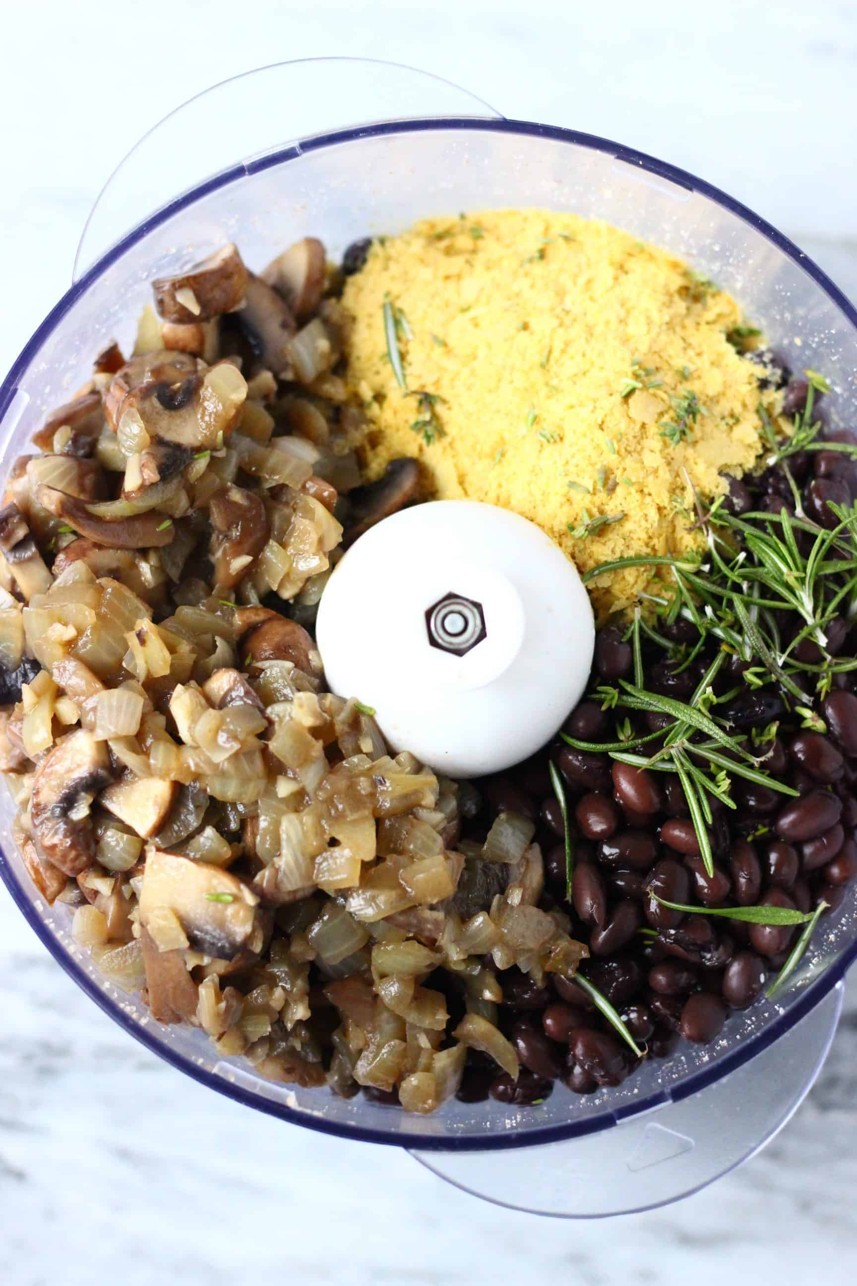 This Vegan Meatloaf is made with hearty black beans, earthy walnuts and savoury mushrooms - it's rich and flavourful, filling and satisfying and super easy to make! Perfect for Christmas, Thanksgiving and everything else in between! Vegetarian, gluten-free, dairy-free and egg-free. #rhiansrecipes #meatloaf #christmas #thanksgiving #vegan #dairyfree #glutenfree #vegetarian Fried onion and mushrooms, nutritional yeast, rosemary, black beans and nutritional yeast in a food processor