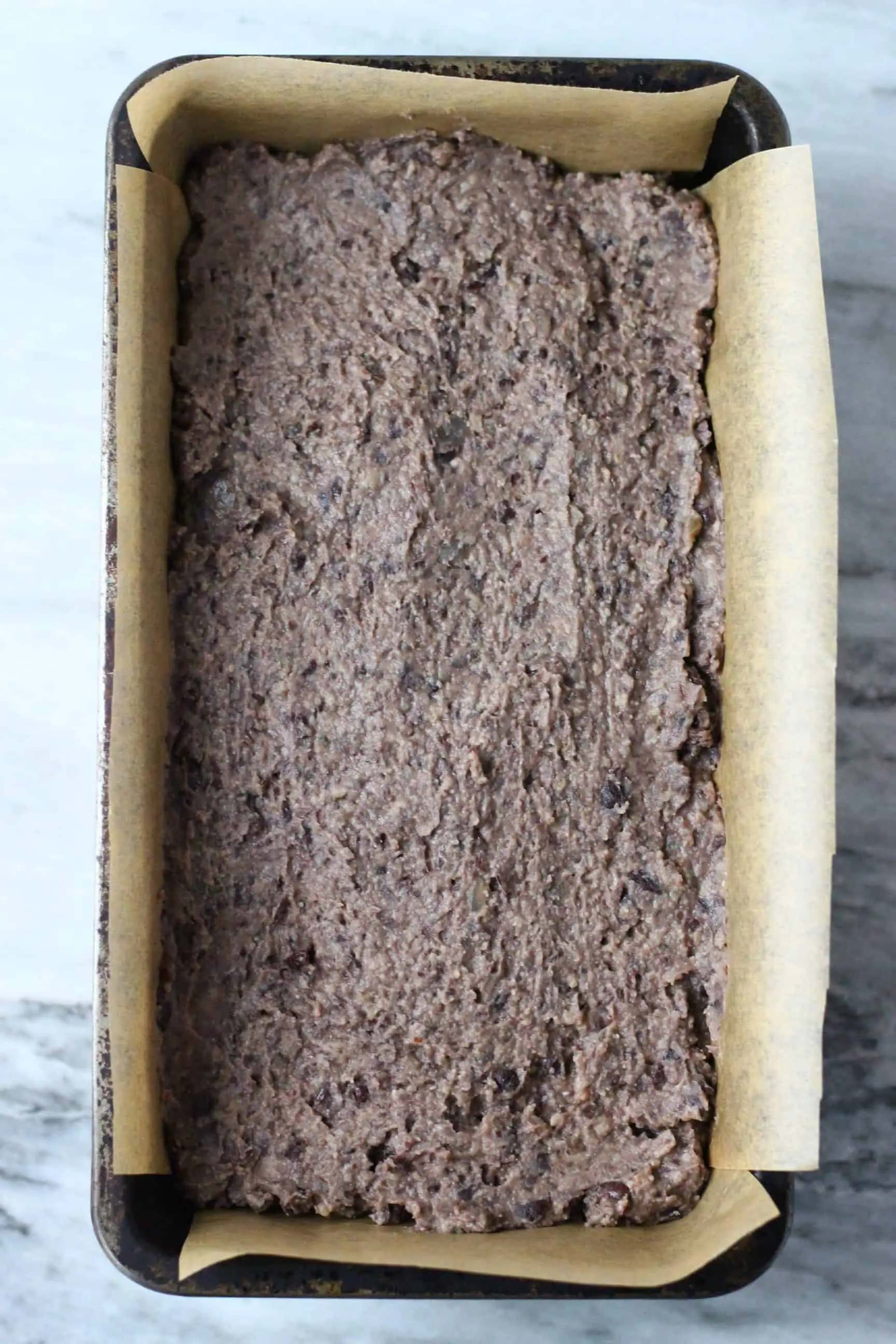 Vegan black bean meatloaf mixture in a loaf tin lined with baking paper 