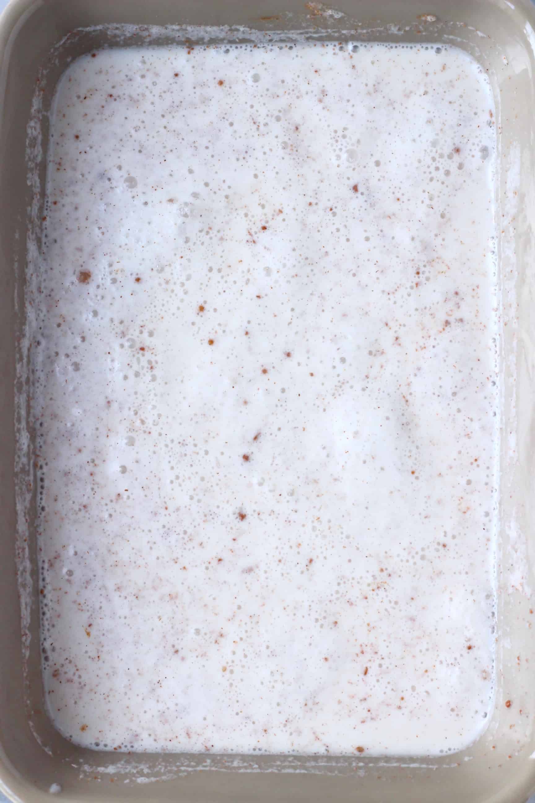 Milk, rice and cinnamon in a grey baking tray