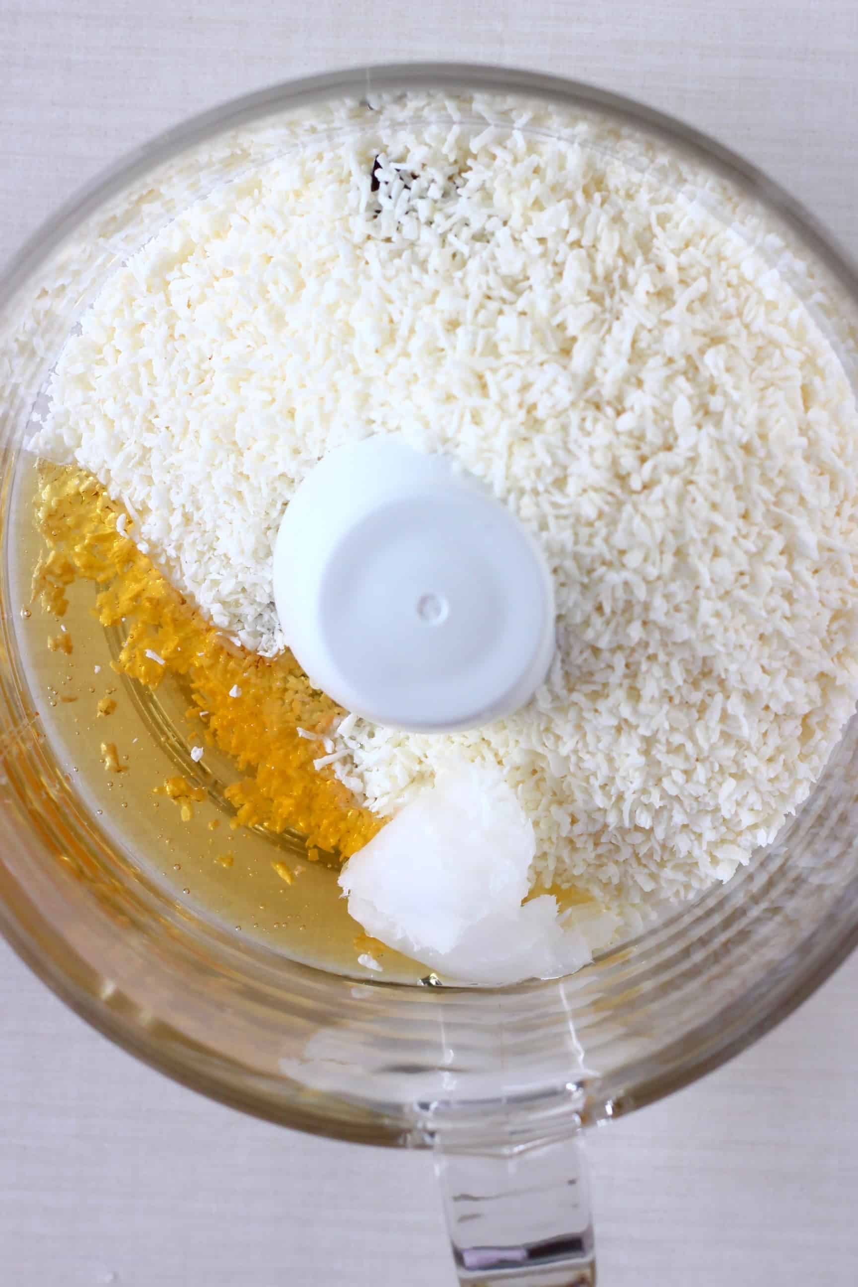 Desiccated coconut, coconut oil and agave syrup in a food processor