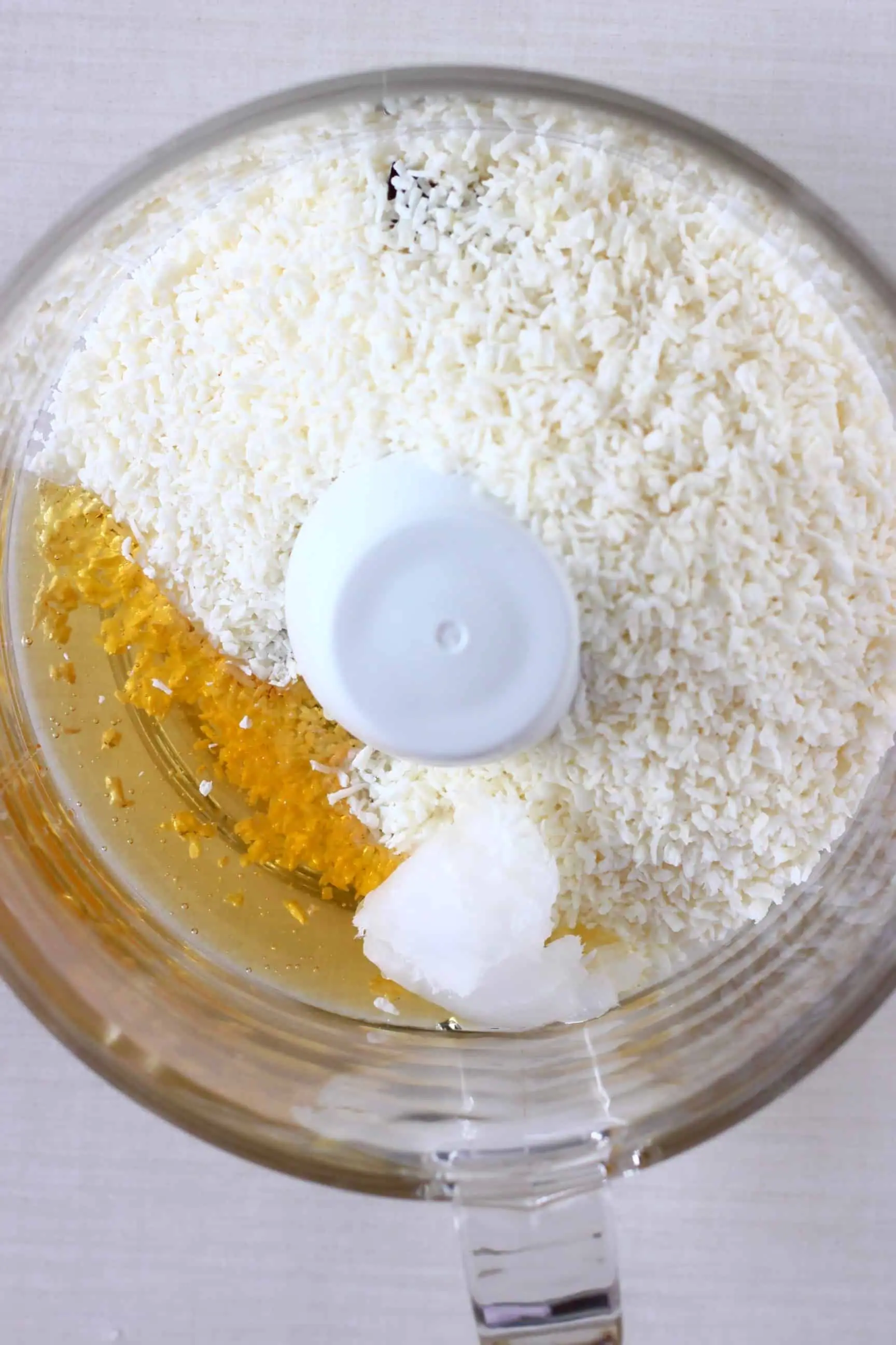 Desiccated coconut, coconut oil and agave syrup in a food processor