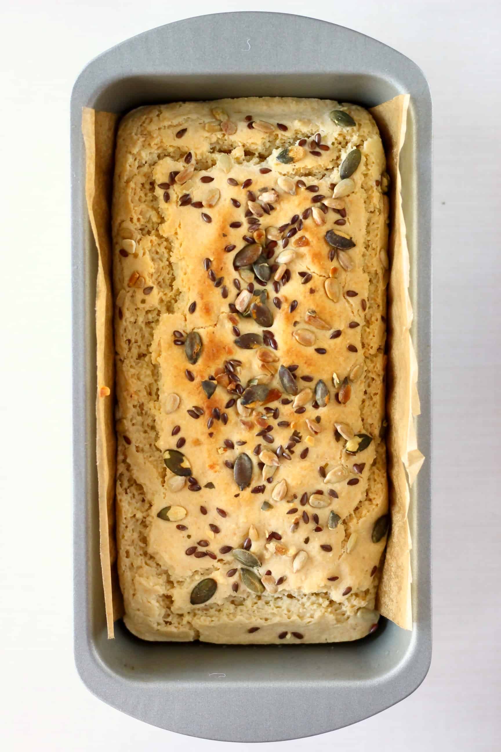 Gluten-free vegan almond bread in a loaf tin lined with brown baking paper