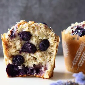 A halved gluten-free vegan blueberry oatmeal muffin with a whole blueberry muffin