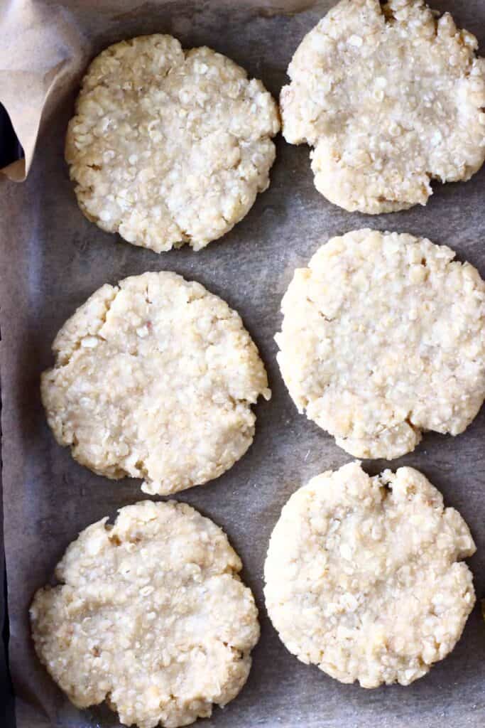 Raw peanut butter oatmeal cookies on a baking tray covered with baking paper
