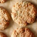 Three golden brown cookies against a sheet of brown baking paper