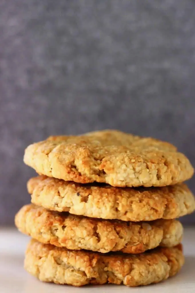 Four golden brown cookies stacked up on top of each other against a grey background