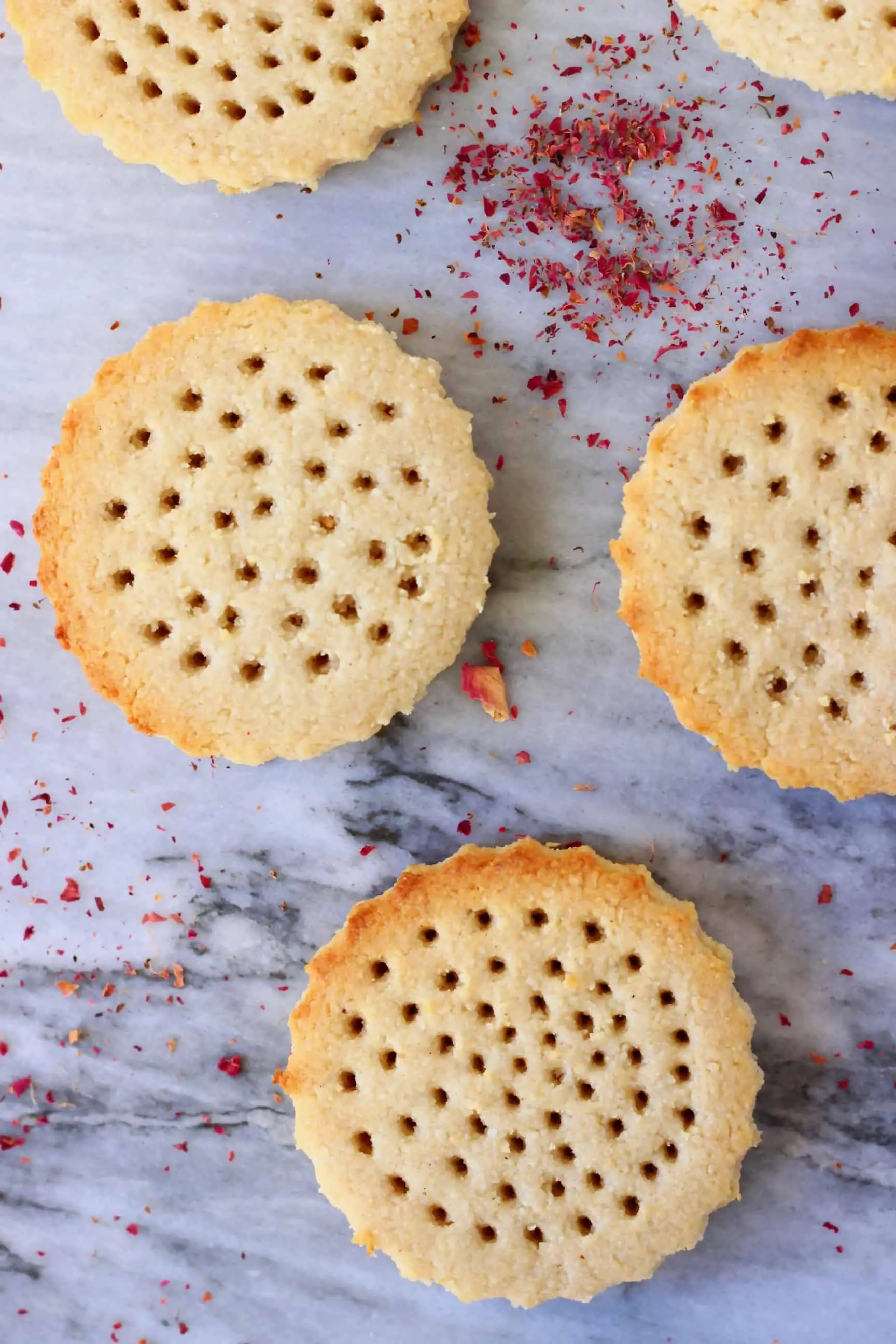 Five vegan shortbread cookies on a marble background