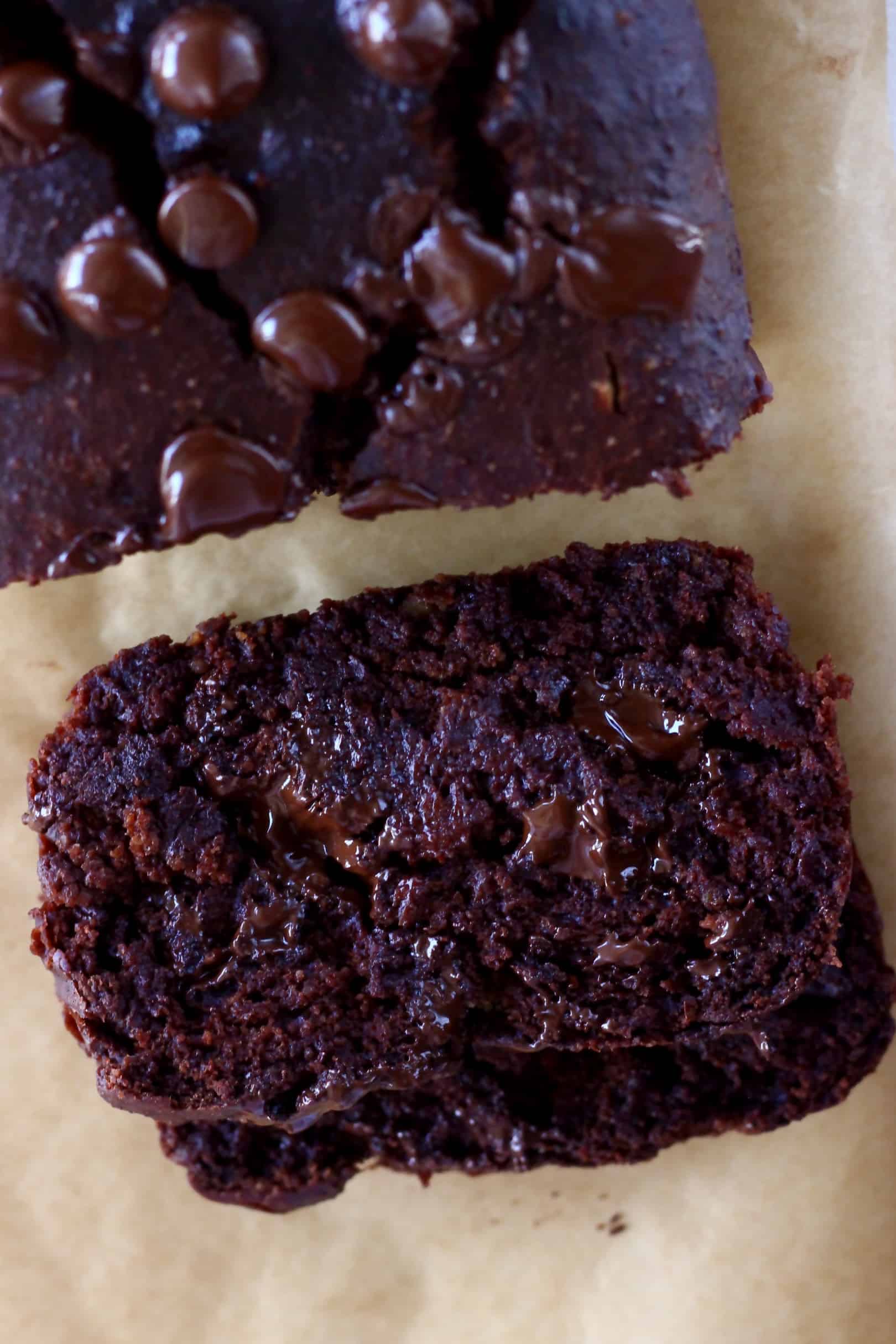 A loaf of gluten-free vegan chocolate banana bread with two slices next to it