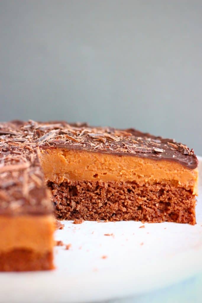 Photo of chocolate sponge topped with chocolate mousse and chocolate ganache against a grey background