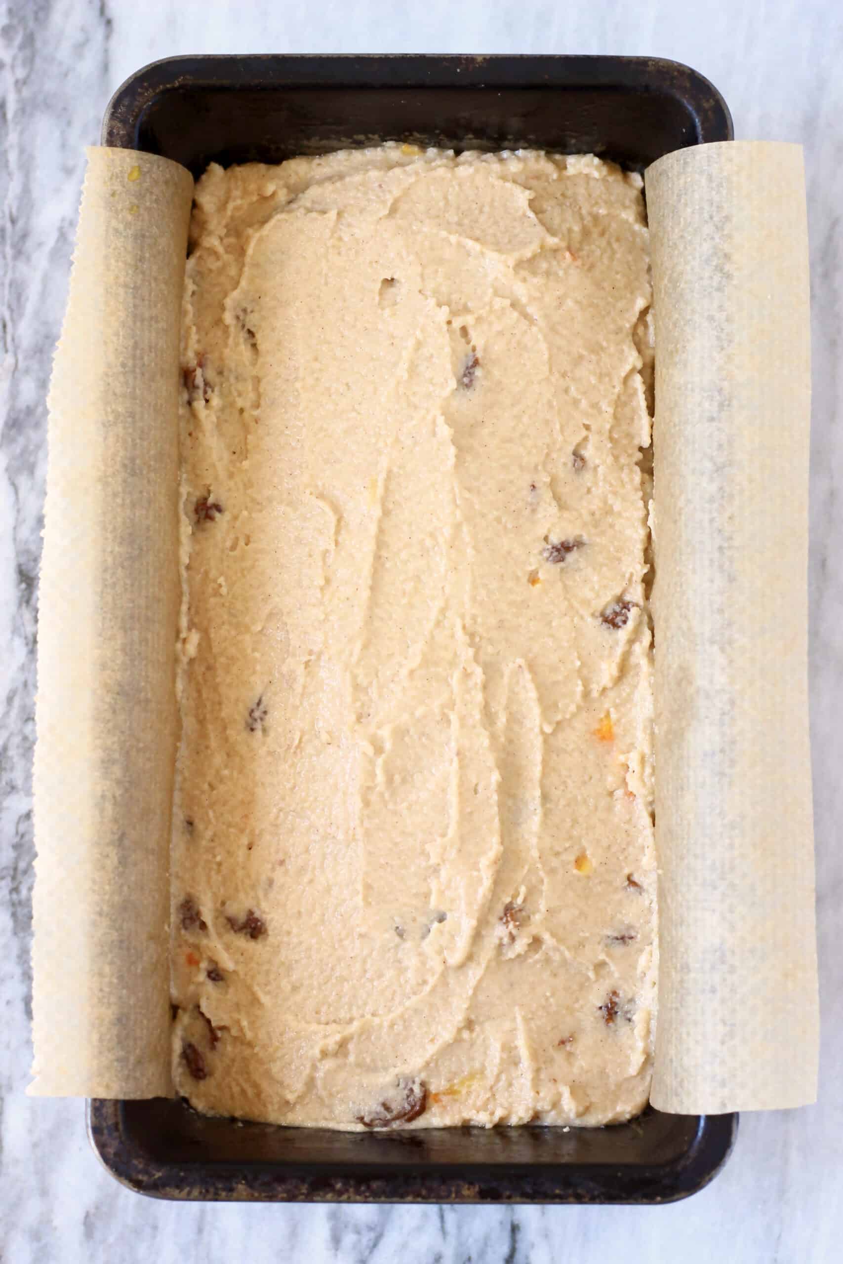 Raw gluten-free vegan hot cross bun loaf batter in a loaf tin lined with baking paper