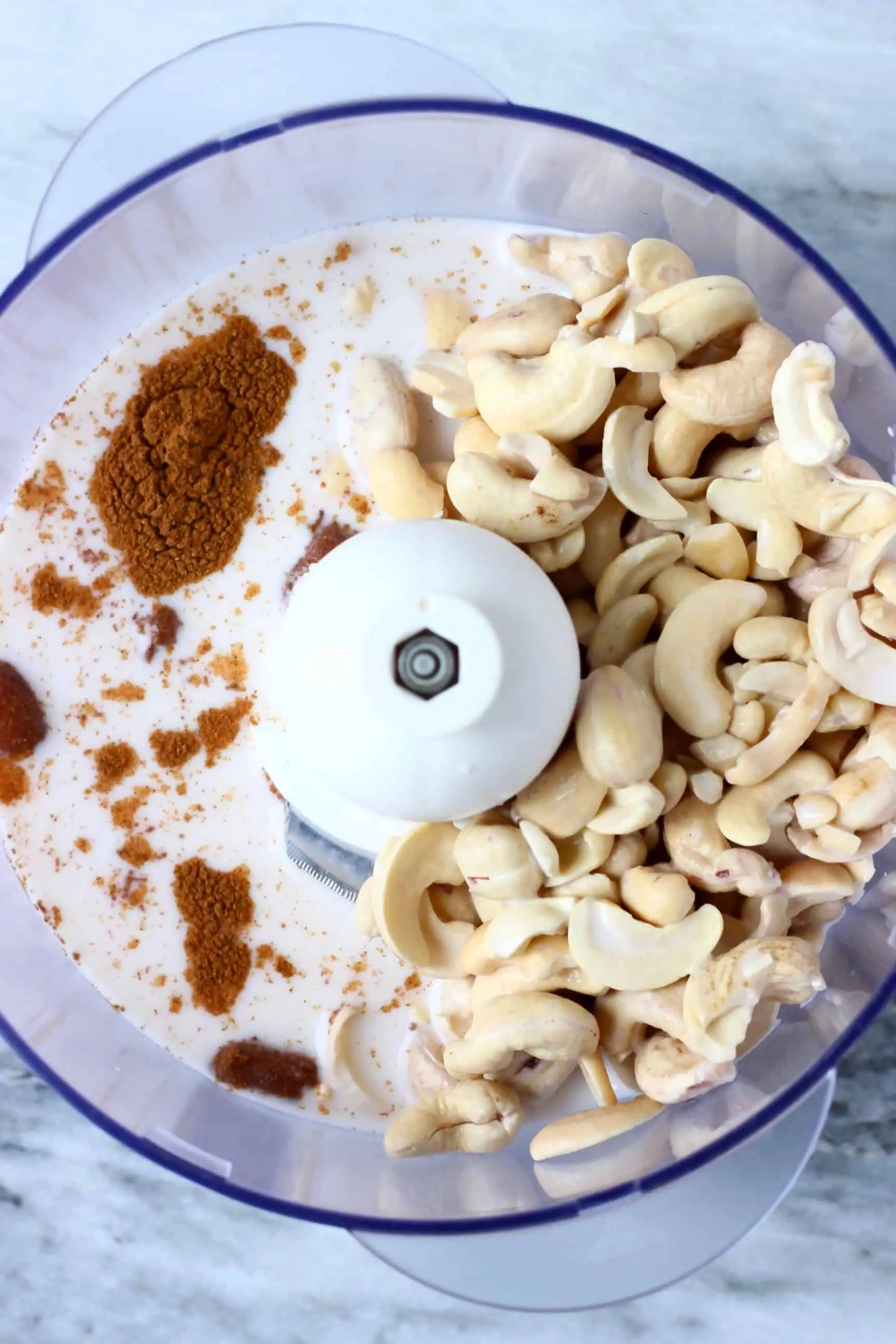 Cashew nuts, cinnamon and milk in a food processor 