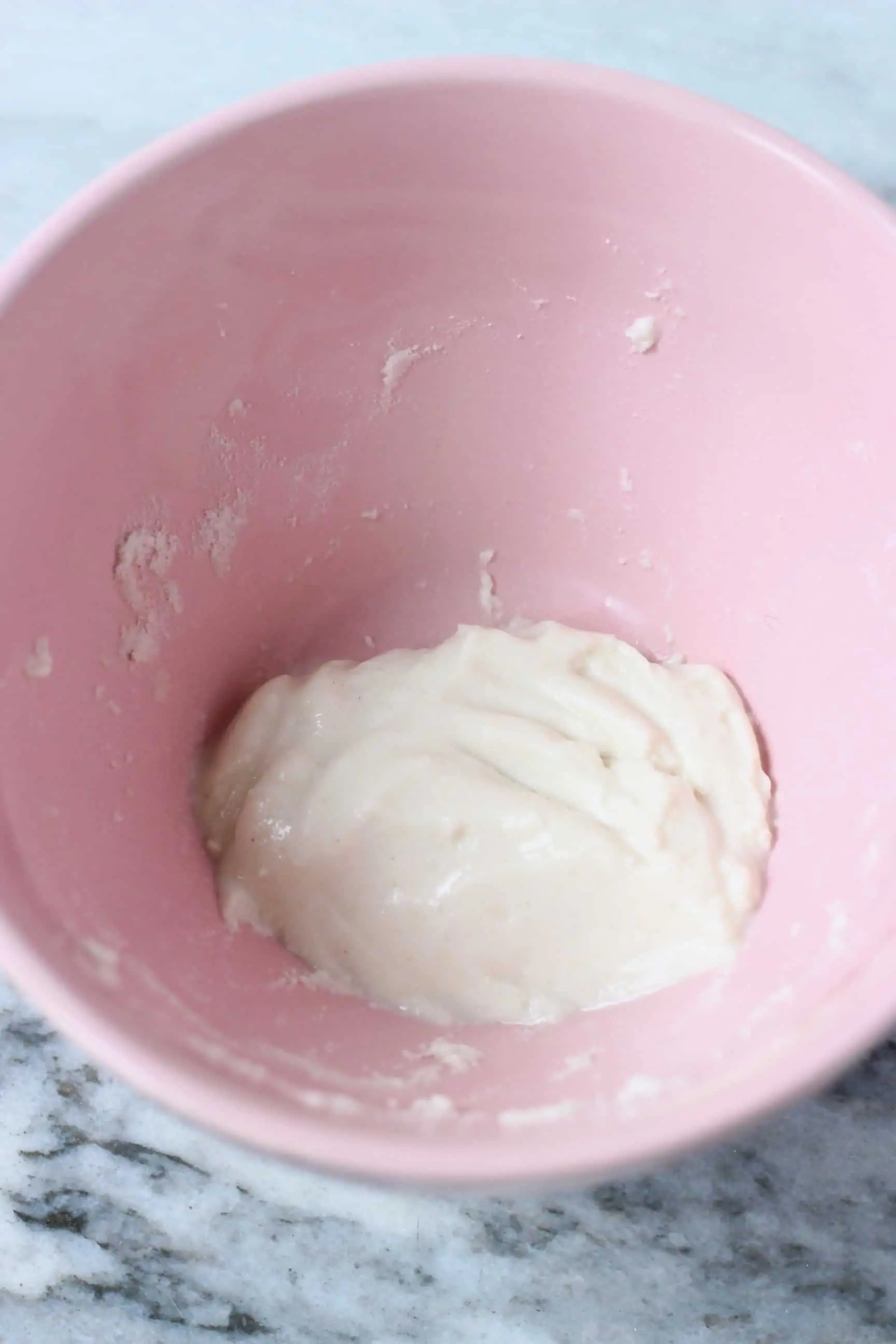 Flour and water paste in a pink bowl against a marble background