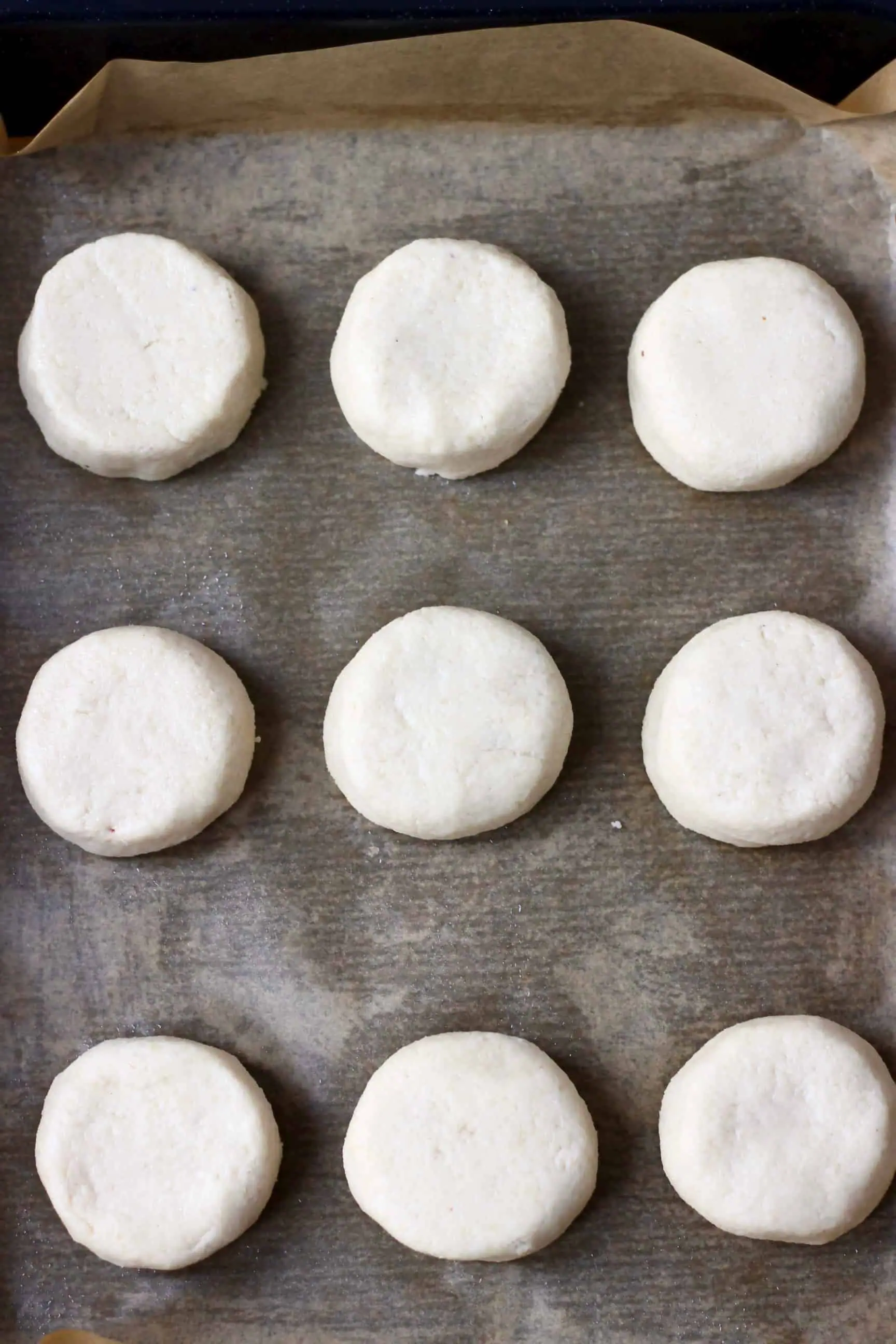 Nine raw gluten-free vegan scones on a baking tray lined with baking paper