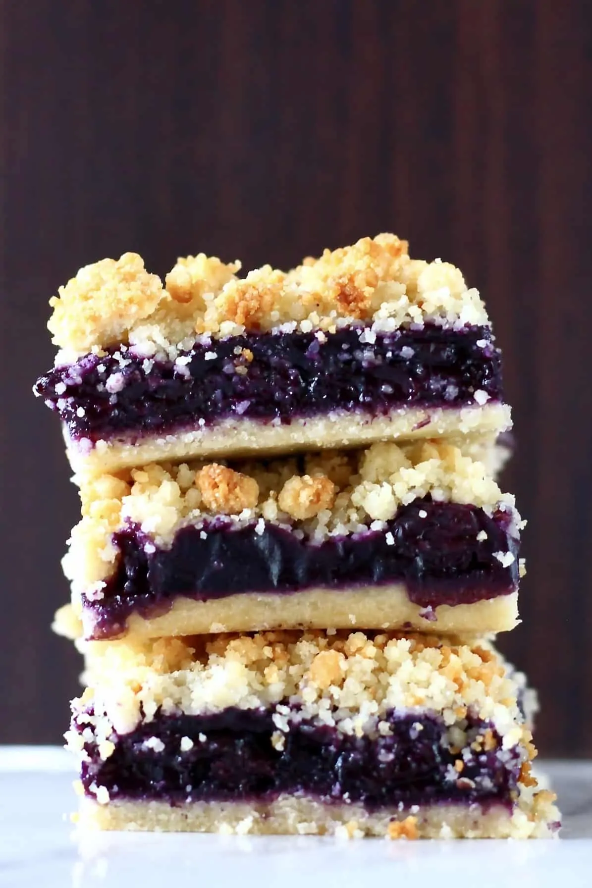 Three blueberry crumble bars stacked on top of each other