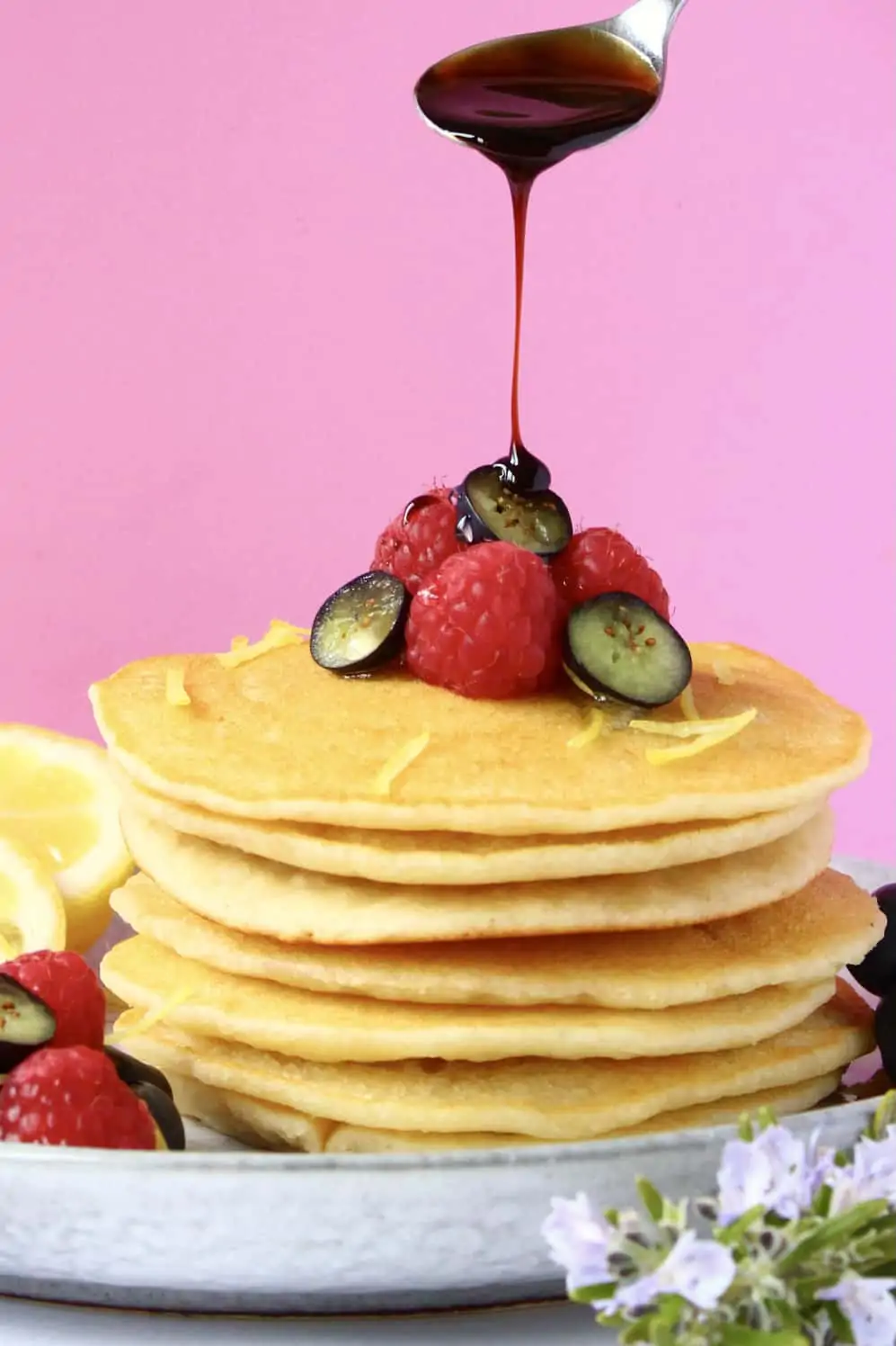 A stack of gluten-free vegan pancakes topped with fresh berries and syrup