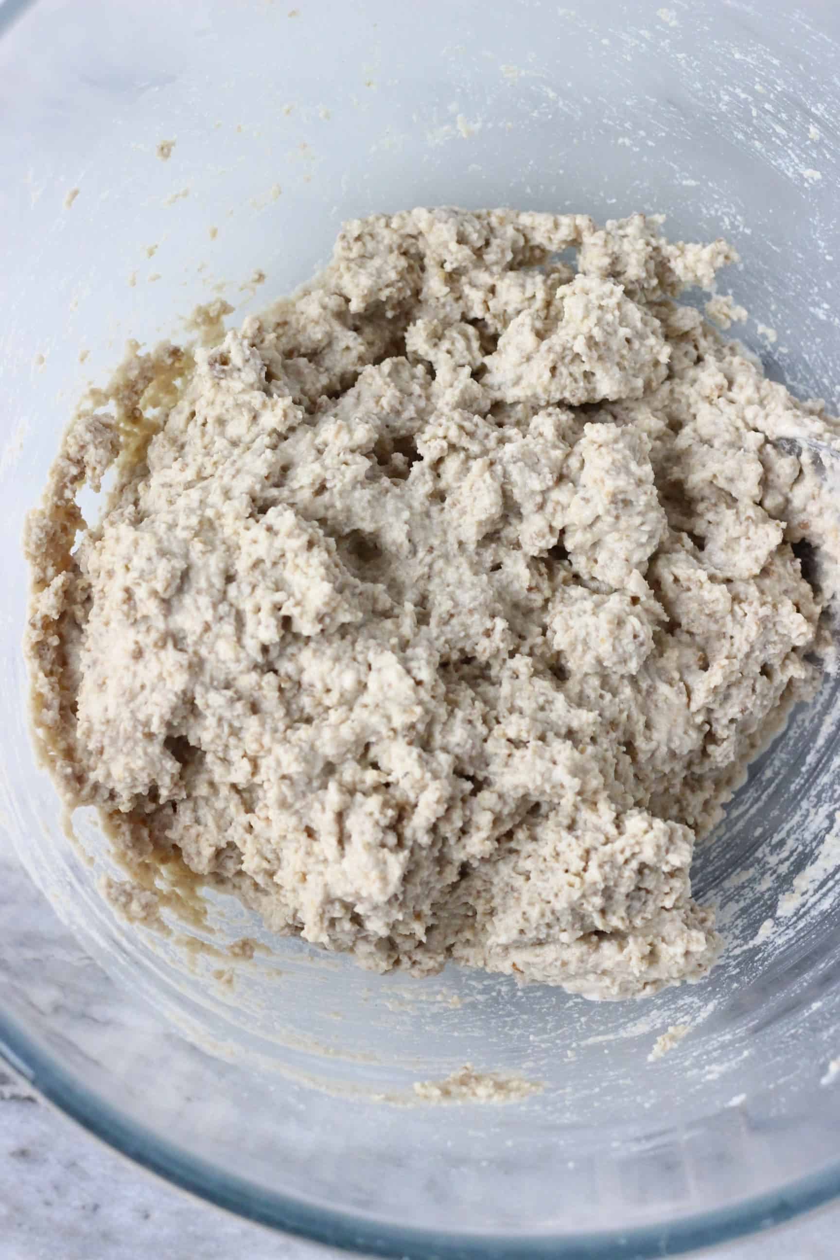 Raw sunflower seed bread batter in a glass mixing bowl 